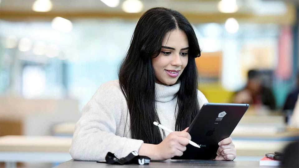 Enhance your learning experience with digital technology at Teesside University Student using an iPad on campus at Teesside University