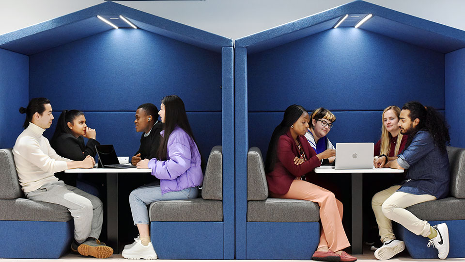 International students on campus sit in in wall cubilcules