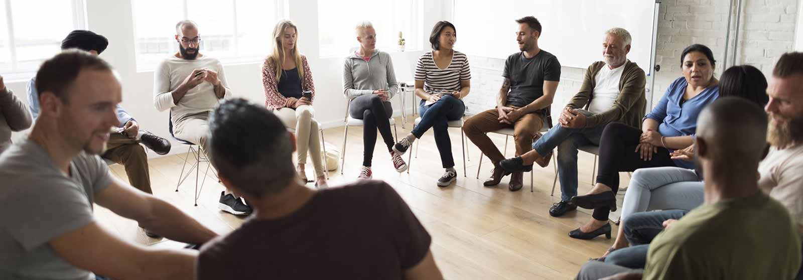 Group of people seated in a circle having a discussion in a casual setting