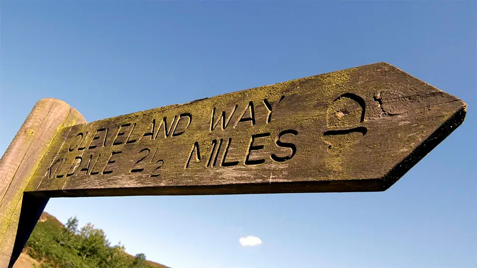 Wooden sign showing distances for walking to Kildale along the Cleveland Way, 2.5 miles