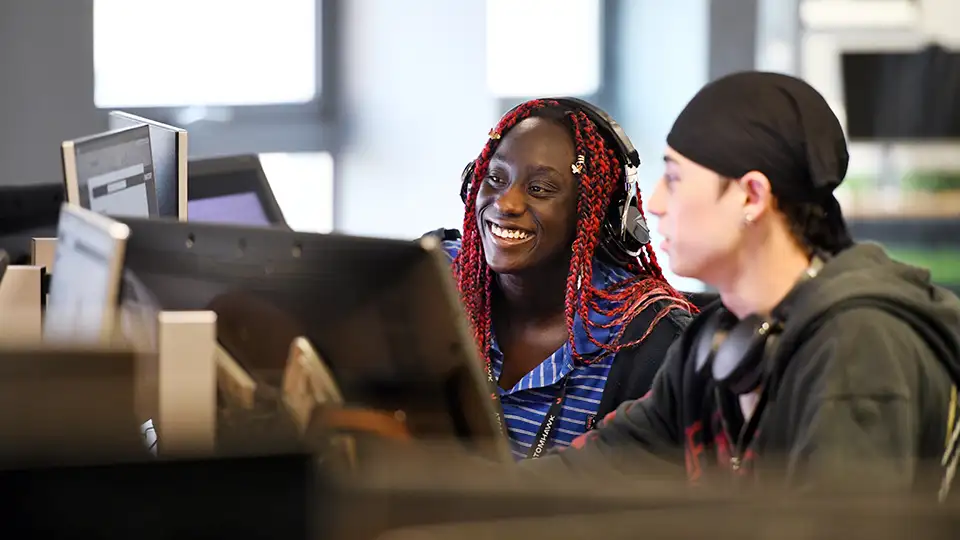 Students in a lab discussing something displayed in the the computer screen