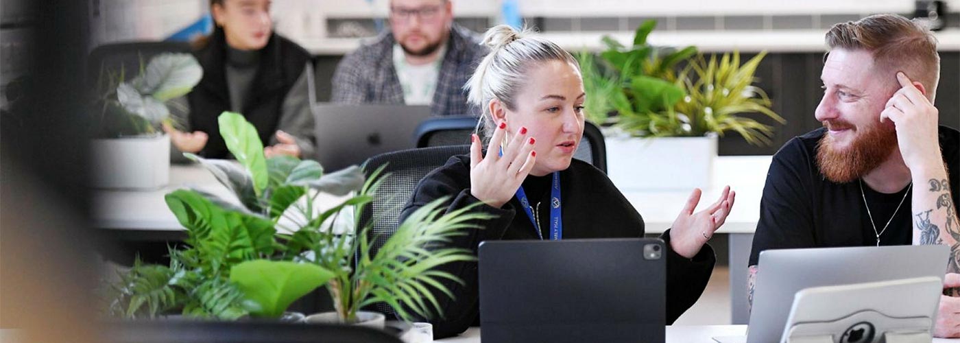 Nathalia Thompson, Biological Sciences graduate at Teesside University, in a lab coat smiling in a university science building