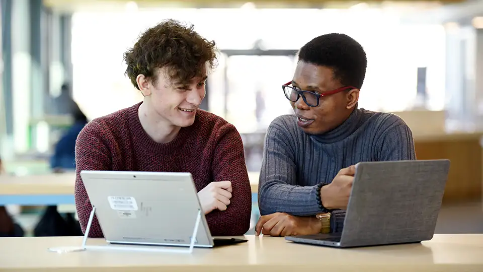 Students sit in a table with their iPads